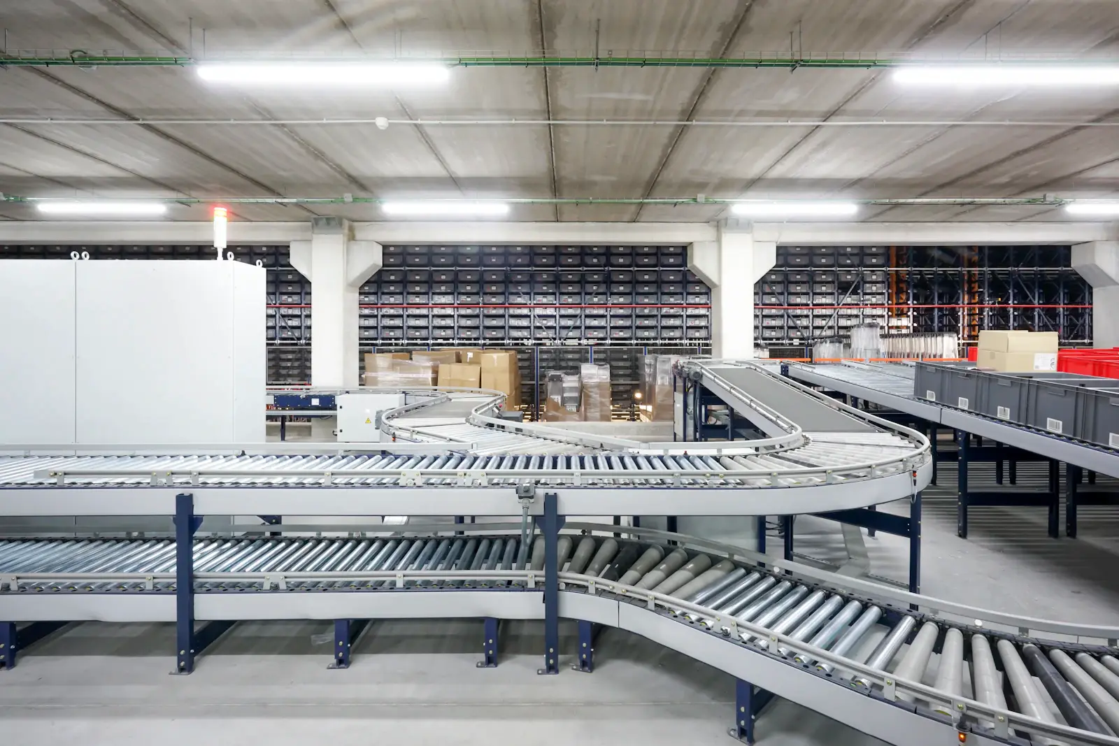 Roller conveyors carrying stock through an automated warehouse